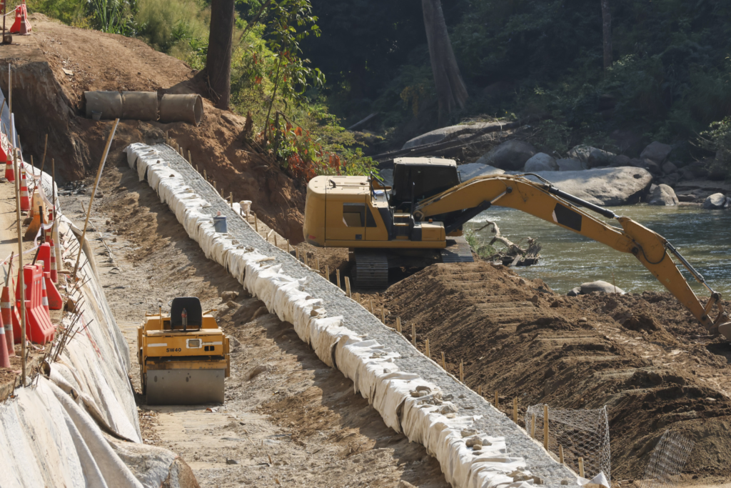 Excavator digging into a steep, rocky dirt bank