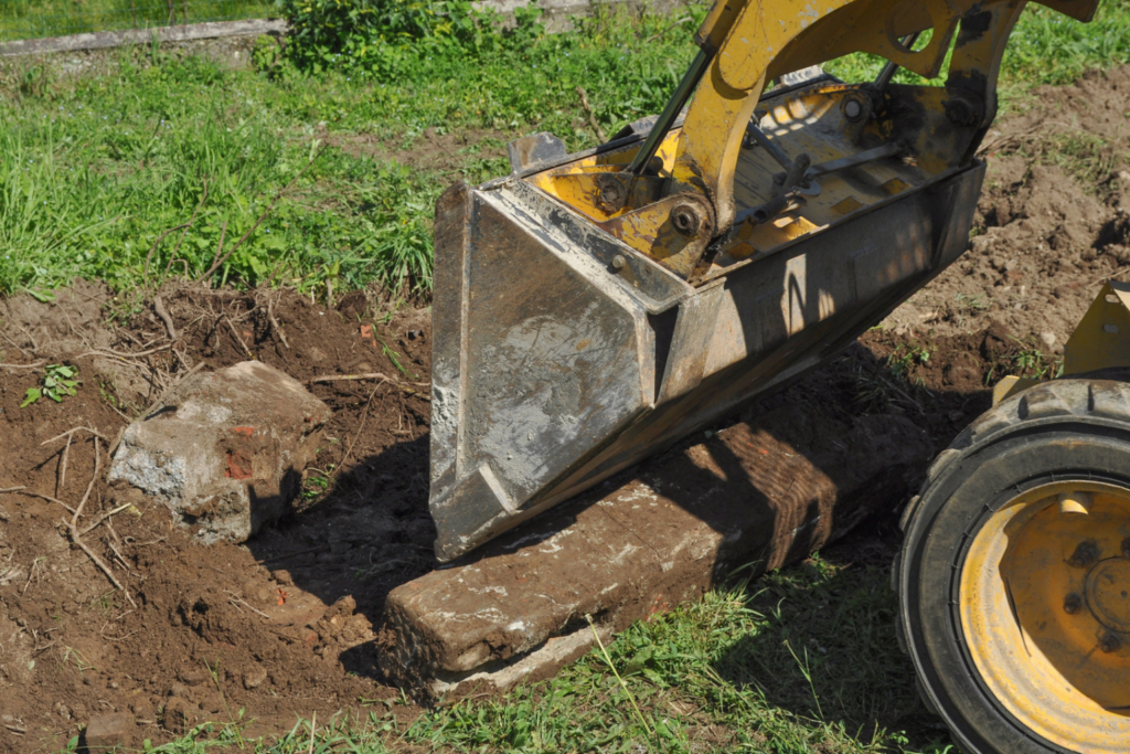 Close-up of heavy machinery pushing a mound of dirt