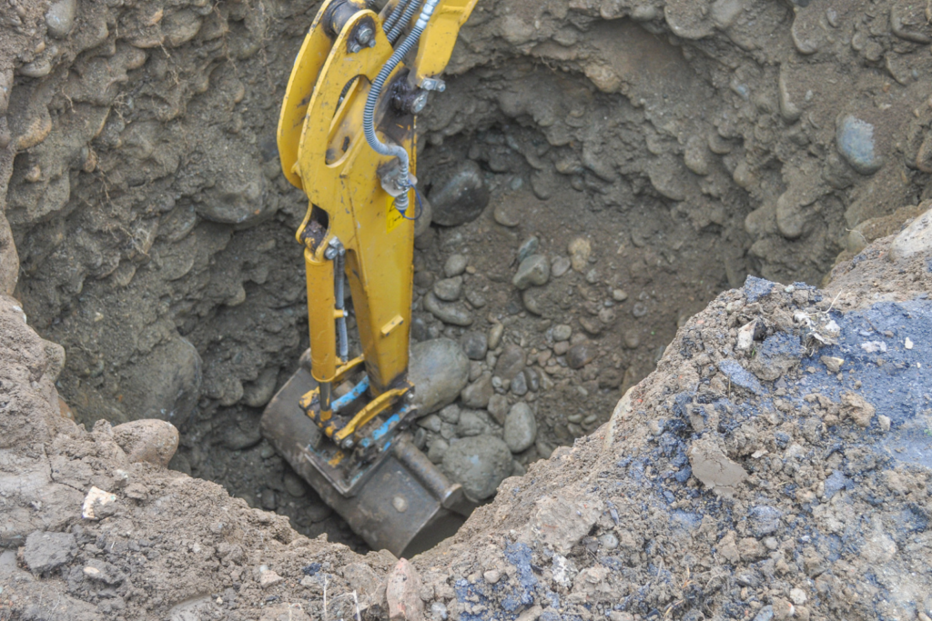 Low-angle view looking up at a yellow excavator bucket