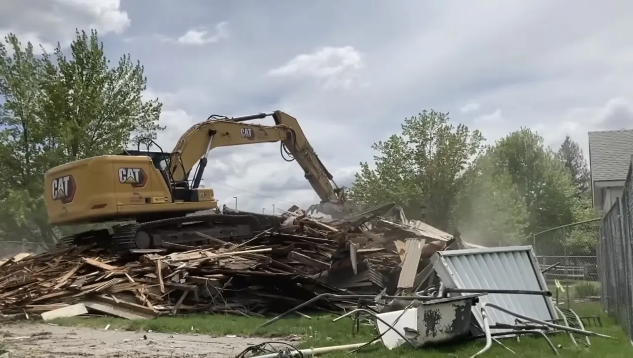 Excavator handling building demolition debris