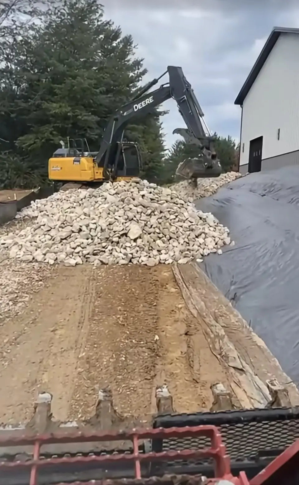 Placing erosion control stone over protective fabric
